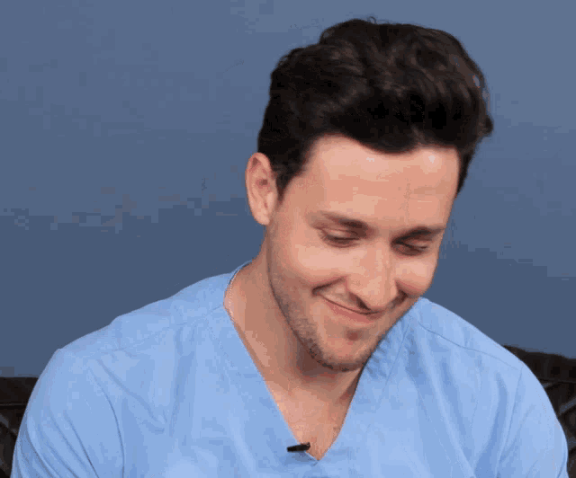 a man wearing a blue scrub top with a microphone on his neck