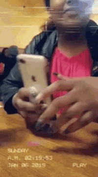 a woman in a red shirt is looking at her phone