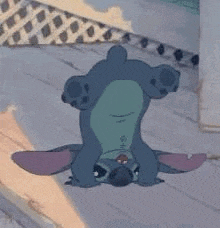 a cartoon character is laying on its back on the floor .