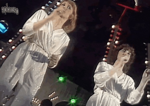 a woman in a white dress is singing into a microphone with the word awanso written above her