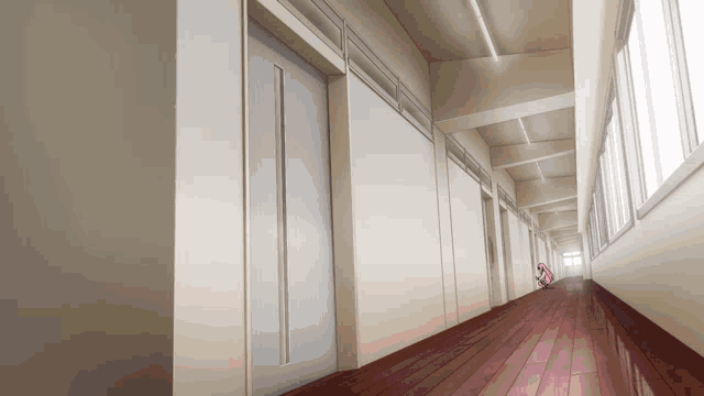 a very long hallway with a lot of windows and doors