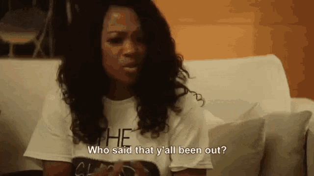 a woman is sitting on a couch and saying `` who said that y all been out ? ''