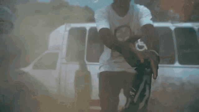 a man is holding a gun in front of a van that says nf services