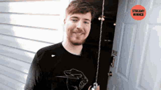 a man is standing in front of a door with a streammy winner sticker on it