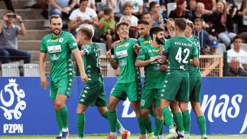 a group of soccer players wearing green uniforms with the number 42 on their backs