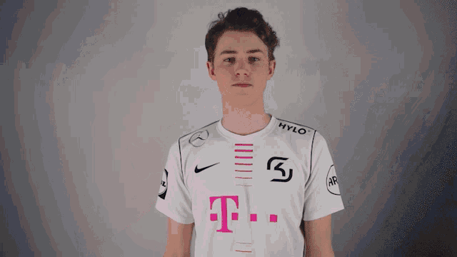 a young man wearing a white shirt with a t-mobile logo on it