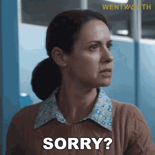a woman in a brown sweater says sorry in white letters