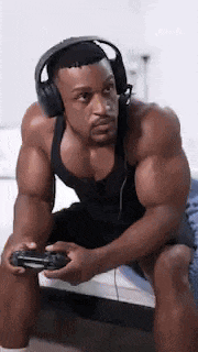 a very muscular man wearing headphones is playing a video game