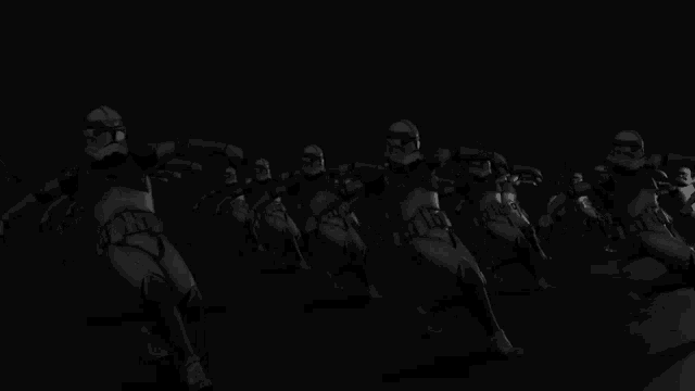 a row of stormtroopers are marching in the dark .