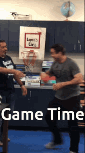 two men are playing basketball in front of a sign that says game time