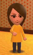 a cartoon character wearing a yellow shirt and black pants is standing in front of a wall with polka dots .