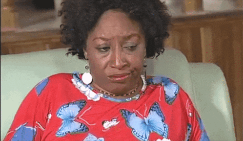 a woman wearing a red shirt with blue butterflies on it is crying