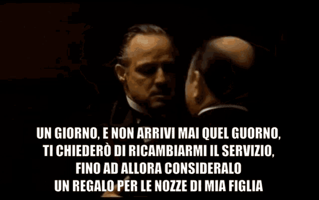 a man in a tuxedo is talking to another man in a suit