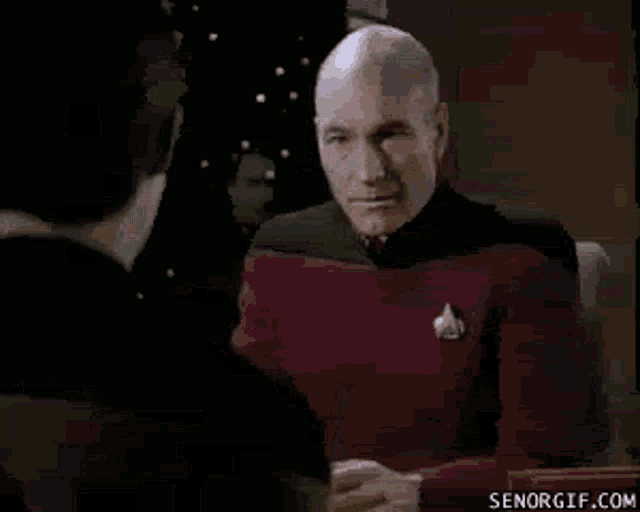 a man in a star trek uniform is standing in front of another man .