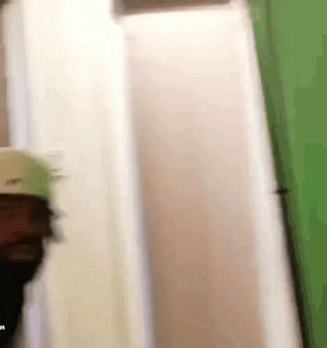 a person is standing in a room with a green wall .