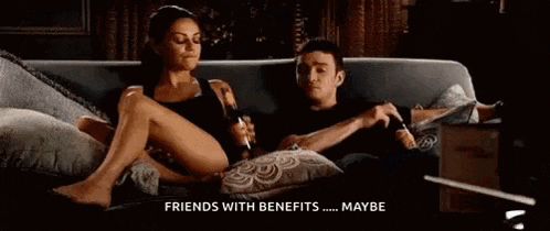 a man and a woman are sitting on a couch . the woman is laying on the man 's lap .