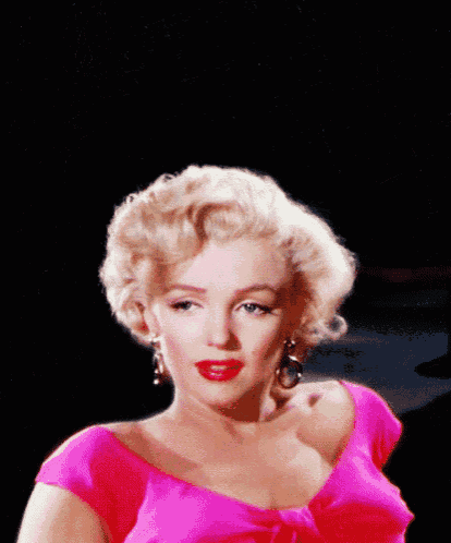 a woman with blonde hair wearing a pink dress and earrings