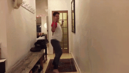 a man is dancing in a hallway in front of a sign that says ' i love you ' on it