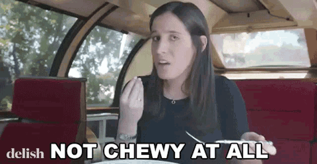 a woman is sitting in a car with the words " not chewy at all " on the bottom