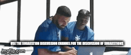 two men in blue shirts are looking at a laptop .