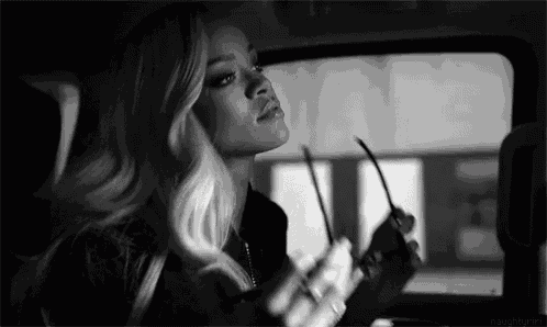 a woman is sitting in the back seat of a car looking out the window .