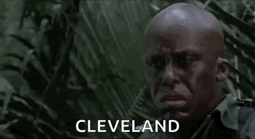 a bald man is standing in the jungle with the word cleveland in the foreground