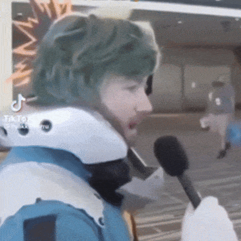 a person in a costume is talking into a microphone while wearing a helmet .