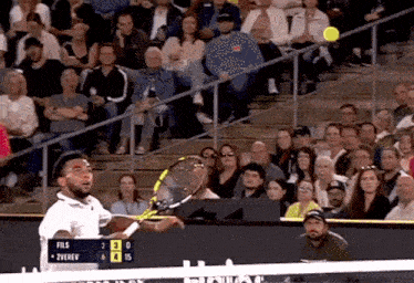 a tennis match between fils and zverev is being played in front of a large crowd