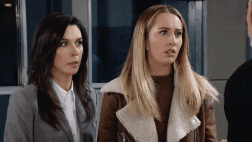 two women are standing next to each other and one is wearing a fur coat