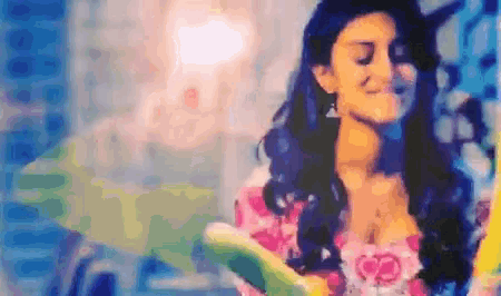 a woman in a floral dress is smiling with her eyes closed in a blurry photo .