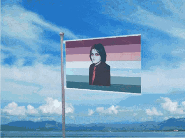 a flag with a picture of a man on it is flying in the wind