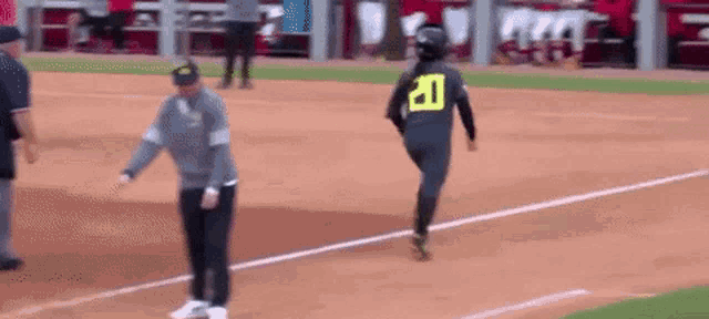 a woman wearing a number 20 jersey is running on a baseball field .