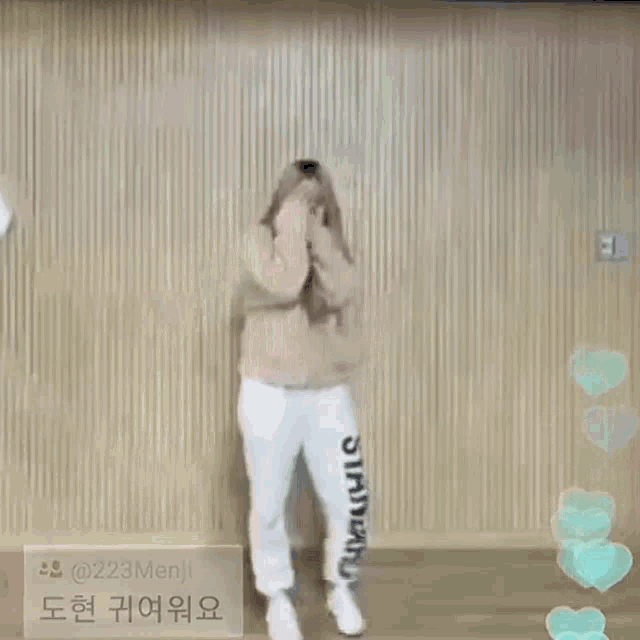 a woman is dancing in front of a wooden wall in a dance studio .