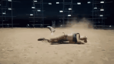 a woman in a bikini is laying on her stomach in the dirt .