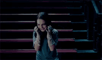 a young girl wearing white gloves is smiling in front of red stairs