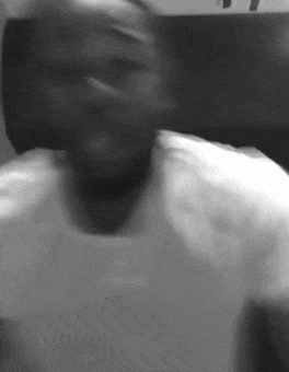 a black and white photo of a man in a white shirt making a face .