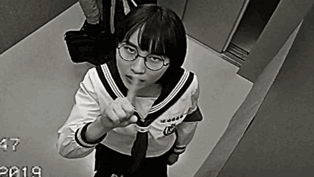 a black and white photo of a girl in an elevator with the year 2019 on the bottom right