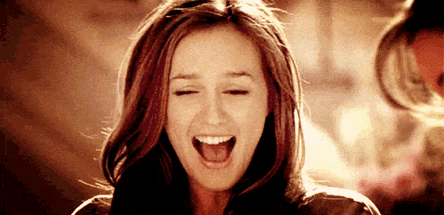 a woman is laughing with her mouth open and her eyes closed