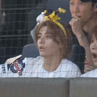 a woman wearing a headband with a pikachu on it watches a game