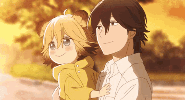 a man is holding a child in his arms and the child is wearing a yellow jacket