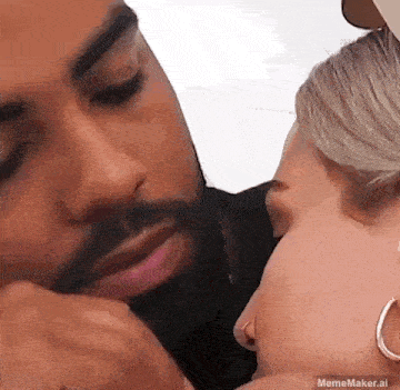 a man is kissing a woman on the forehead .