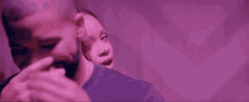 a man and a woman are standing next to each other in a room with purple lights .