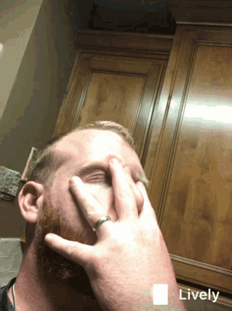 a man with a ring on his finger is covering his eyes and the word lively is on the bottom right