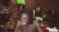 a blurry picture of a group of people sitting at a table in a room .