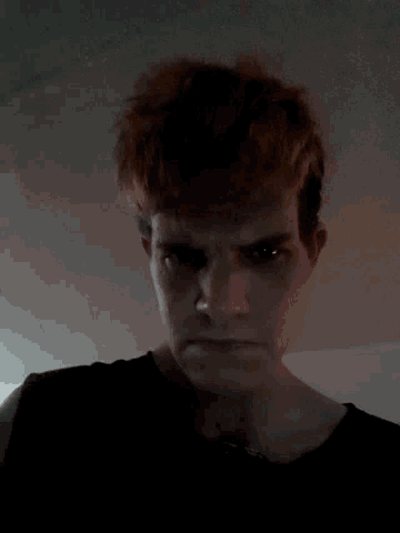 a close up of a person 's face with a dark background