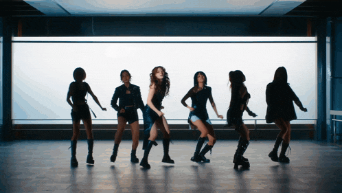 a group of women are dancing in a room