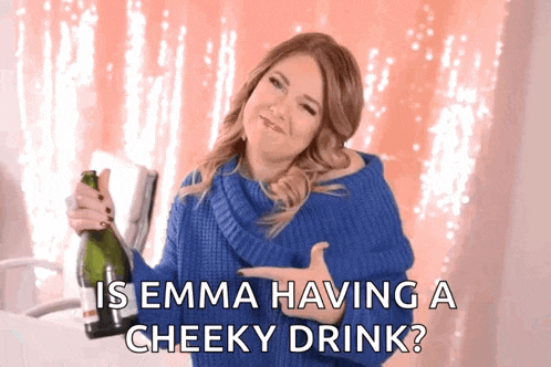 a woman in a blue sweater is holding a bottle of champagne and saying is emma having a cheeky drink ?
