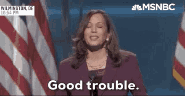 a woman in a purple suit says good trouble
