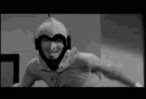 a black and white photo of a man in a superhero costume