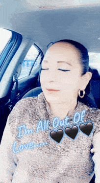 a woman is sitting in the back seat of a car with her eyes closed